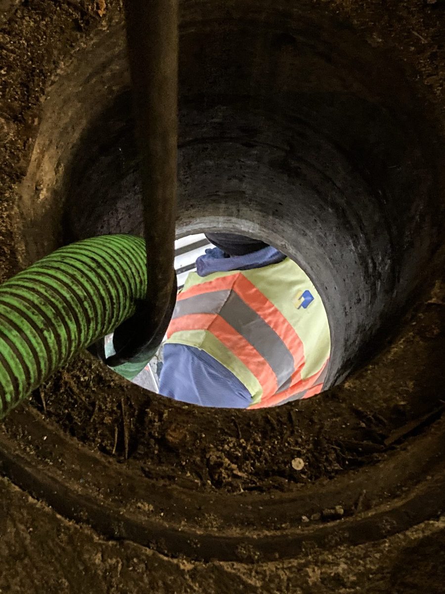 Heavy-duty JN Grease hose routed deep into a facility access point